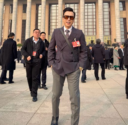 甄子丹妇女节低调派花给路人 手拿大袋依旧双手送出鲜花很有礼貌