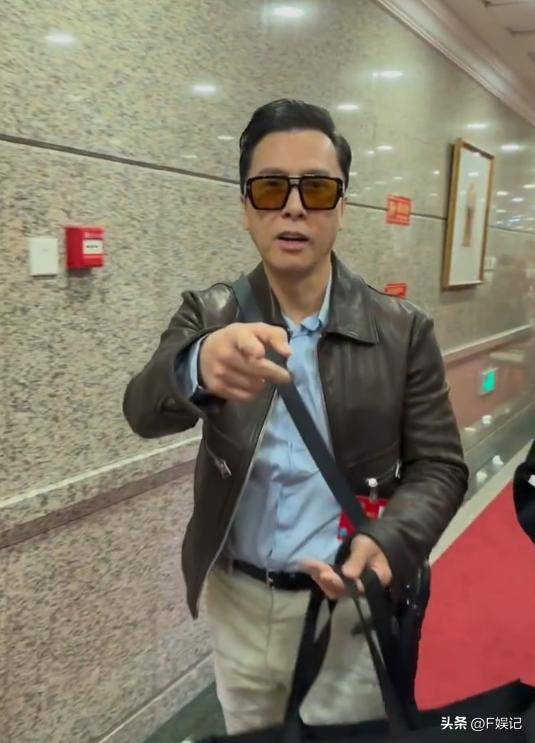 甄子丹妇女节低调派花给路人 手拿大袋子依旧双手送出鲜花很有礼貌