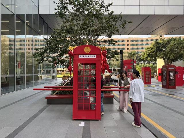 工作日下午，在位于中庭的“记忆剧场”，遛娃的妈妈们带孩子坐进电话亭改造成的“花轿”。鲁怡 摄
