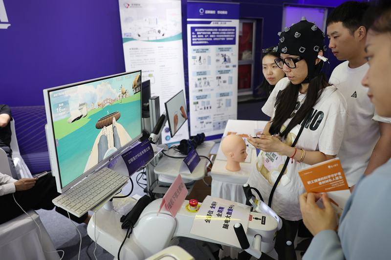 2025年6月26日，在丰台区举办的第二届智能医工产业创新发展大会上，工作人员演示脑机接口设备。新京报记者 陶冉 摄