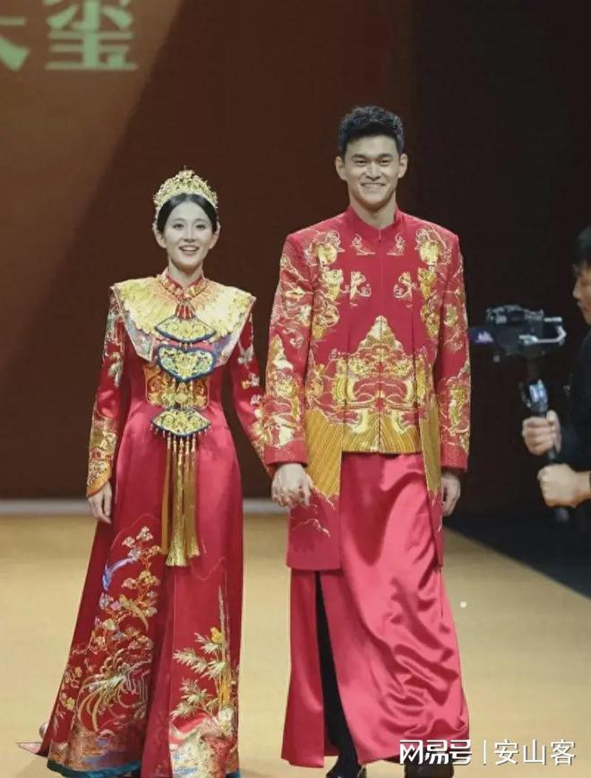 孙杨张豆豆牵手走秀，两人身穿中式礼服，相视一笑，仿佛婚礼现场