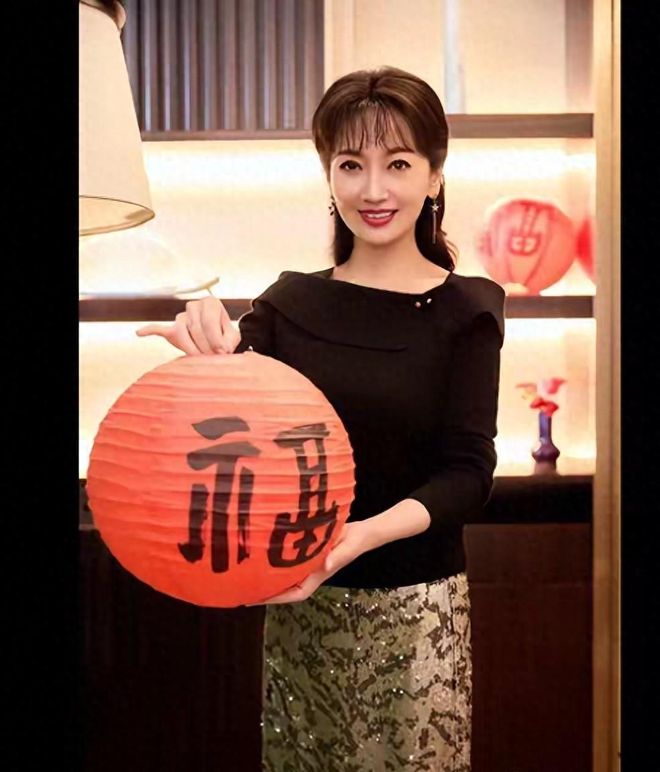 赵雅芝黑色上衣搭配格纹长裙，手提福字，气质不凡，不像70多岁人