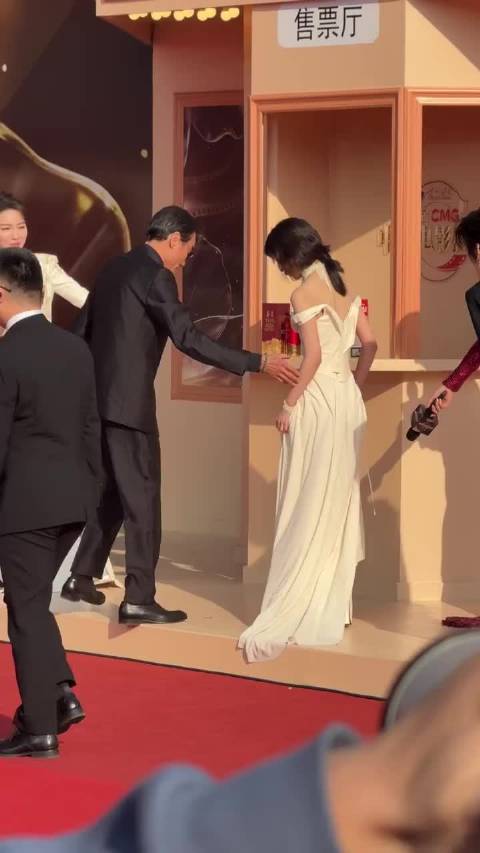 梁家辉红毯贴心帮张子枫整理裙摆