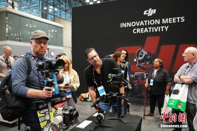 资料图：美国纽约影像博览会上，大疆展位的相机手持稳定器等设备受到关注。 中新社记者 廖攀 摄