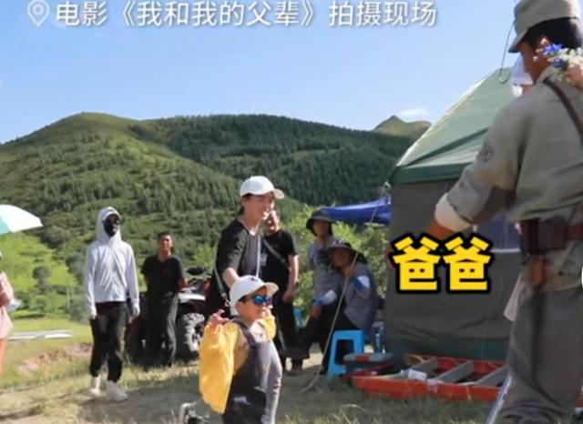 谢楠带俩娃探班吴京,孩子马上钻进父亲怀里,大儿子还送花给爸爸