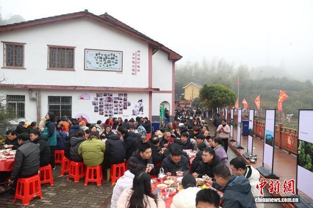图为2月1日，在江西井冈山市神山村，一场别开生面的神山宴人气火爆，墙面上的今昔对比“笑脸墙”颇为醒目。刘力鑫 摄