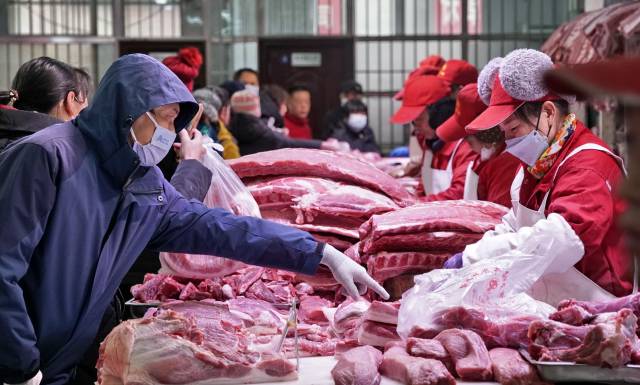 北京市民在新发地农产品批发市场内购买猪肉。新华社资料图