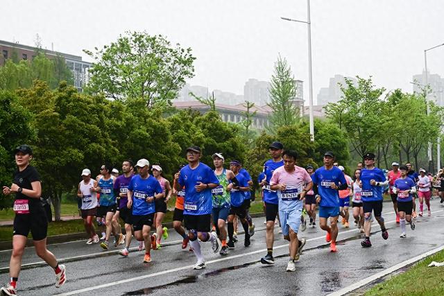 2026年4月12日，南京，2026南京仙林半程马拉松开跑，图为冒雨参加比赛的马拉松选手们。视觉中国 图