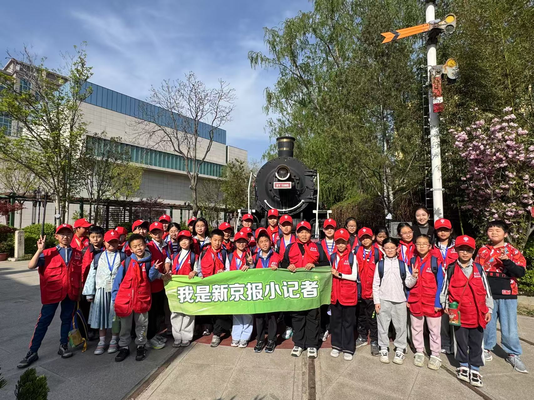 新京報小記者在鐵科院院史館蒸汽機車前合照。新京報記者 徐彥琳 攝