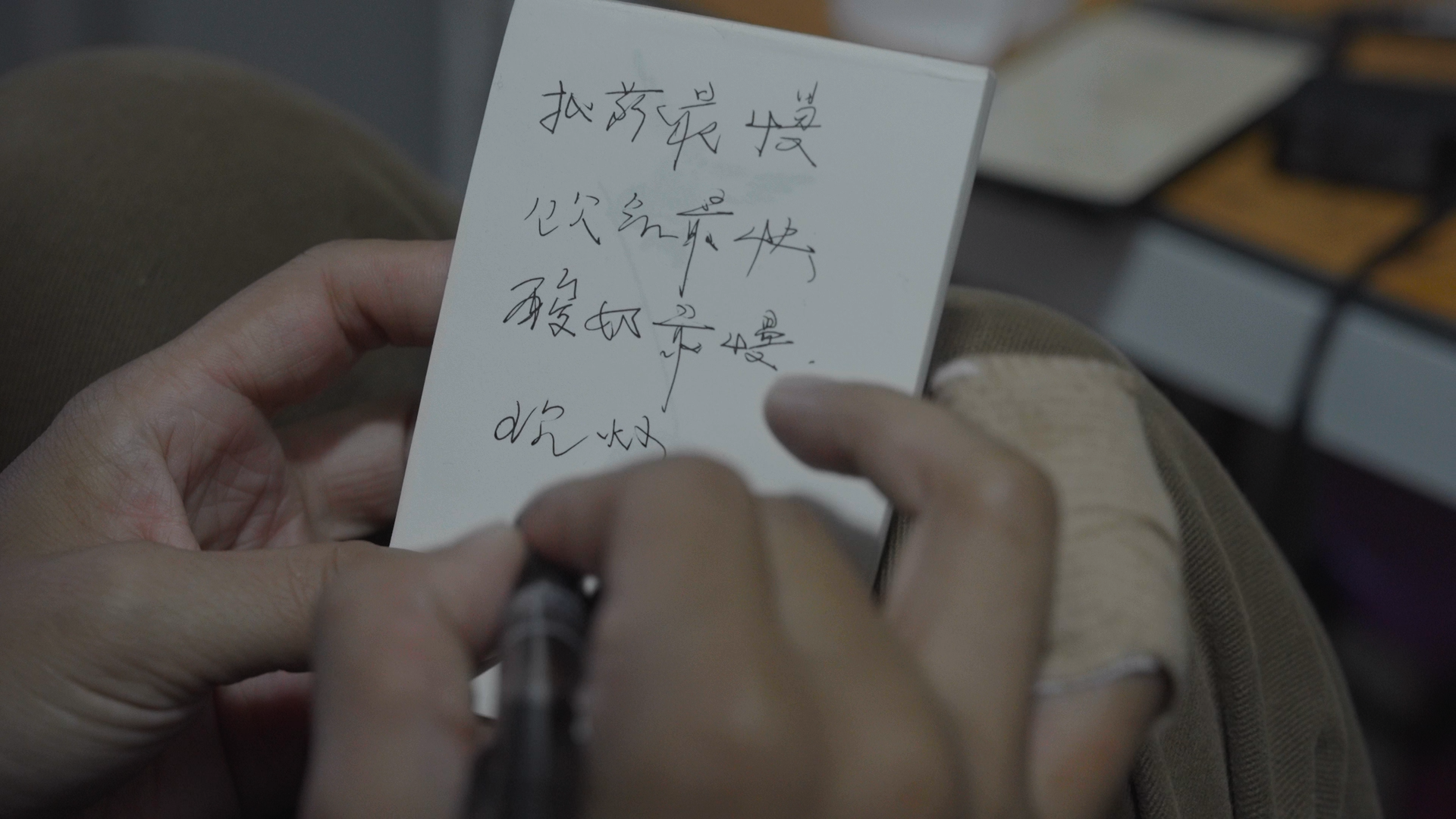 王晚做筆記，寫字手的小拇指在騎行中受傷。新京報記者 吳瑜 攝
