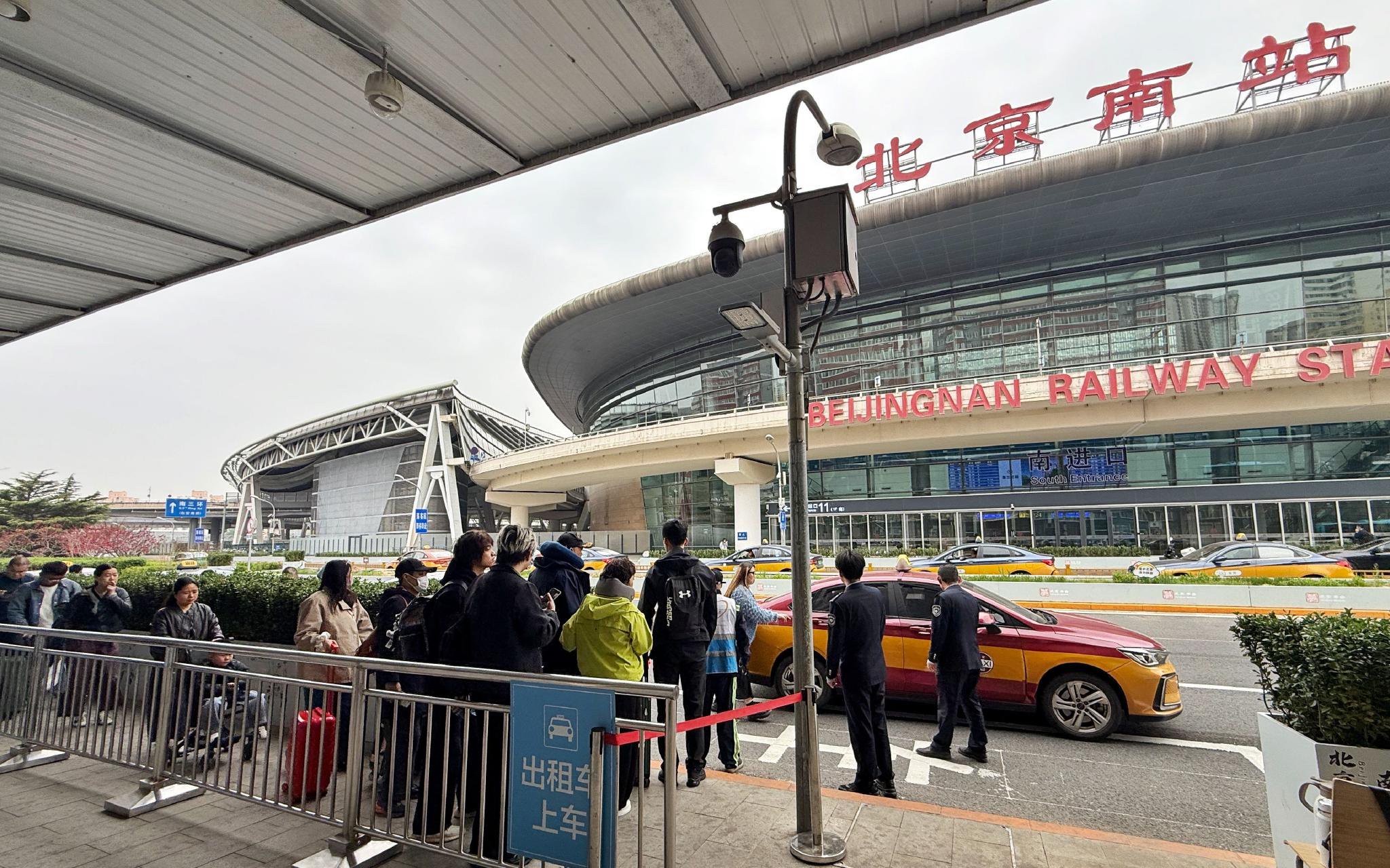 4月14日中午12點，北京南站南樞紐出租車調度站上車點，旅客正有序排隊上車。新京報記者 王貴彬 攝