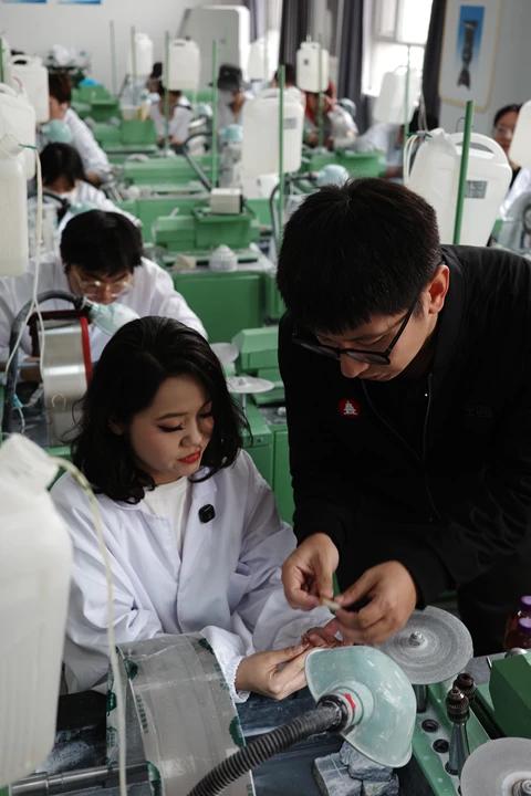 4月13日，昆玉職業技術學院玉雕課上，一位學生向沈罕詢問玉石造型問題。新京報記者 戴軒 攝