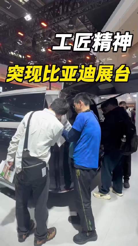 日本参观者北京车展持卷尺测量比亚迪展车