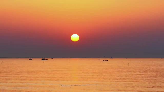 在日照东港用手机拍照记录一场海上日出