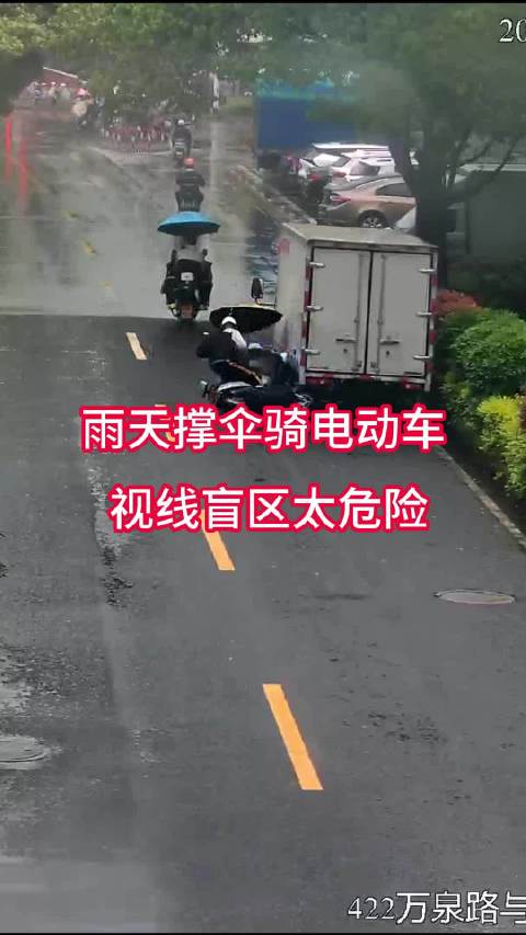 雨天撑伞骑电动车 视线盲区太危险！
