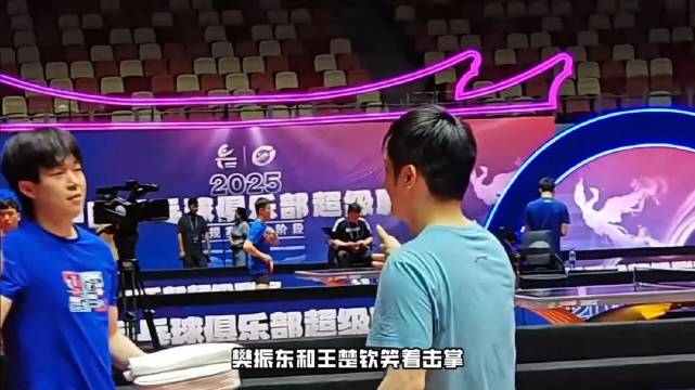 樊振东看到王楚钦主动上前，二人笑着击掌如老友寒暄，还摸摸肚子