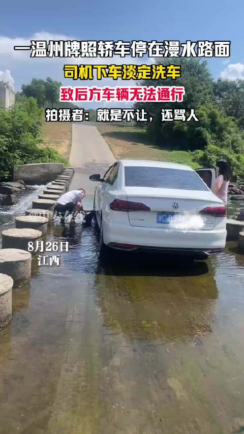 轿车停在漫水路面，司机下车淡定洗车，致后方车辆无法通行