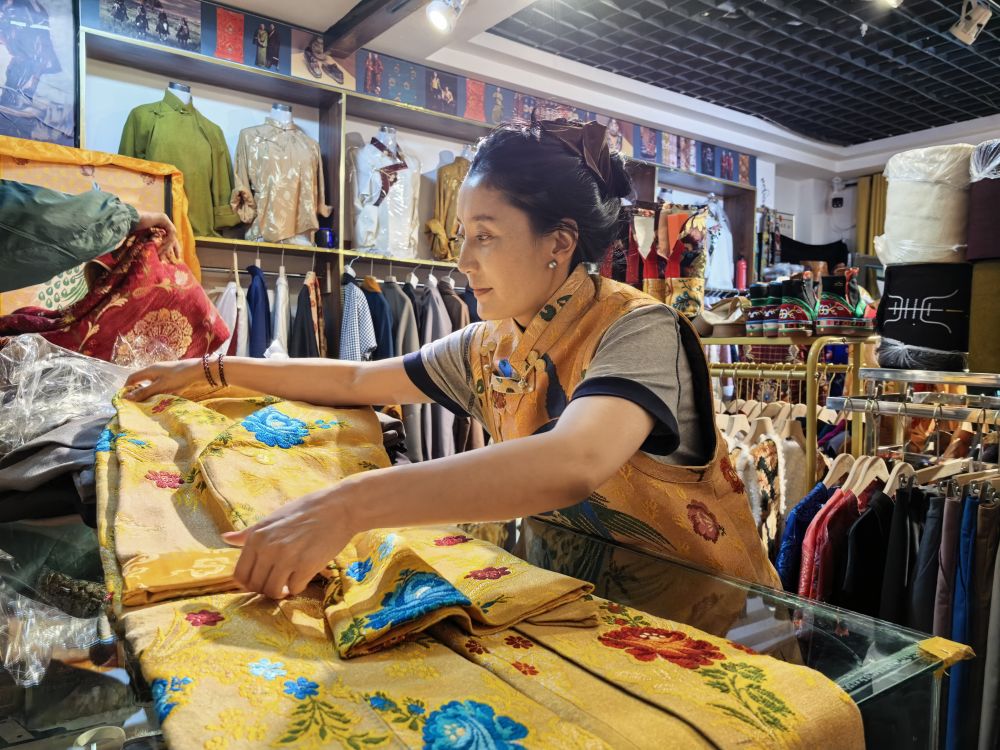 2026年7月8日，藏服店主白瑪著措正在整理從尼泊爾進口來的服飾。新華社記者柳澤興 攝