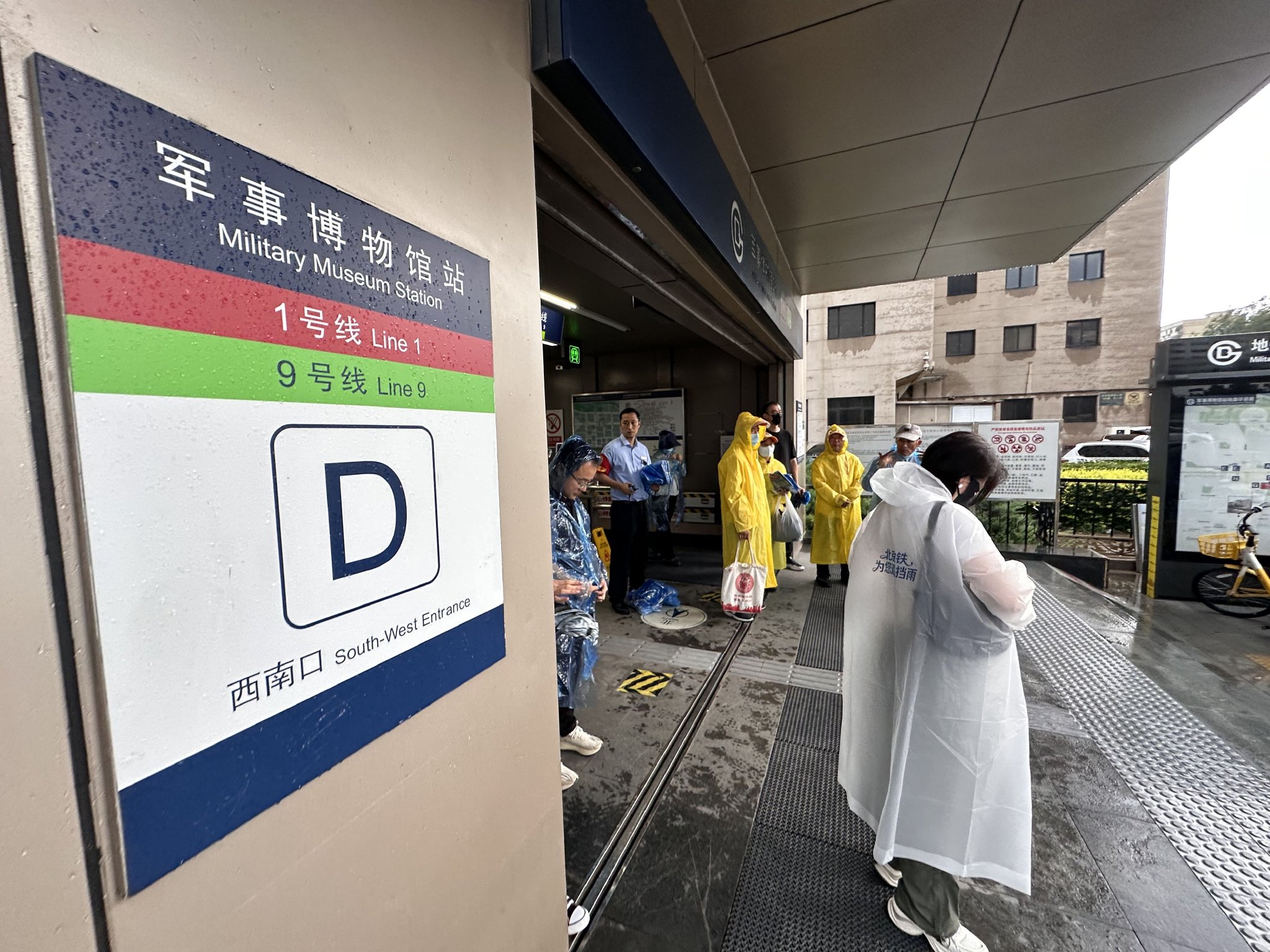 北京地鐵1號線八通線軍事博物館站，穿戴好雨衣的乘客準備離站。新京報記者 王貴彬 攝