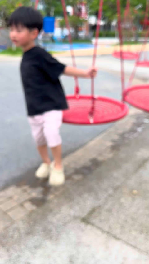 小朋友坐秋千瞬间化身快乐小旋风