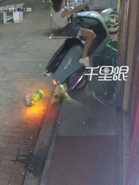 女子扶车忘熄火摩托被径直骑上墙