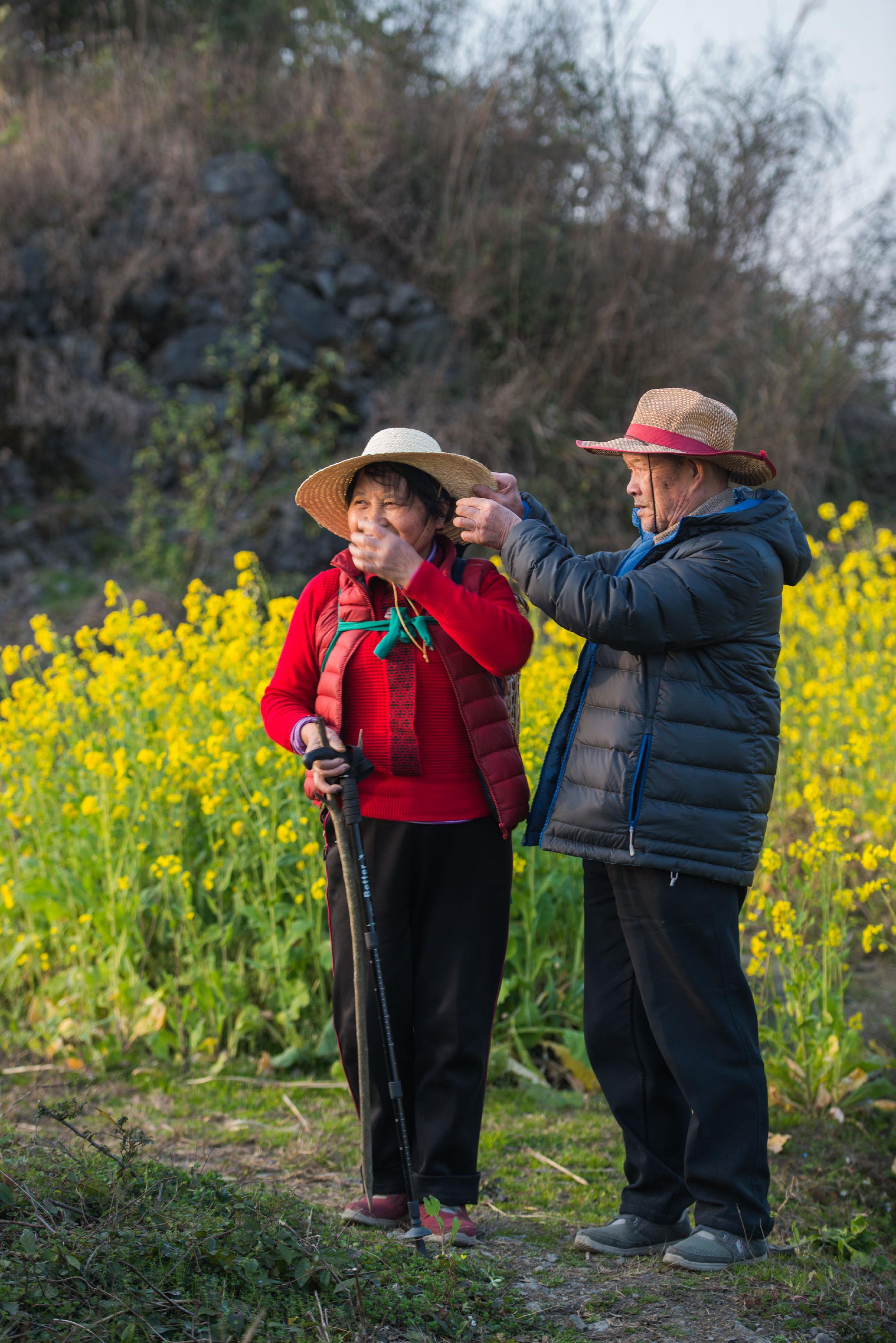 「2019年，我們去打野菜，媽的草帽粘了野草，爸幫她取下來，被我抓拍到了。」圖片由出版社提供。