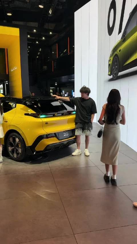 逛车展准备离场时，男生一眼相中喜欢的车，拉着女友兴致勃勃科普讲解…
