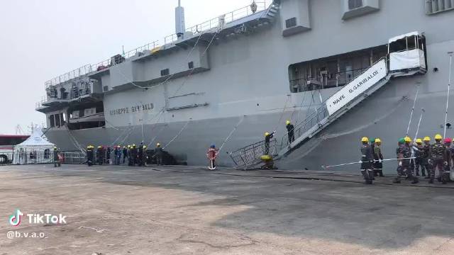 印尼工人开始给原“加里波第”号小航母刷漆，舰尾还挂着意大利国旗