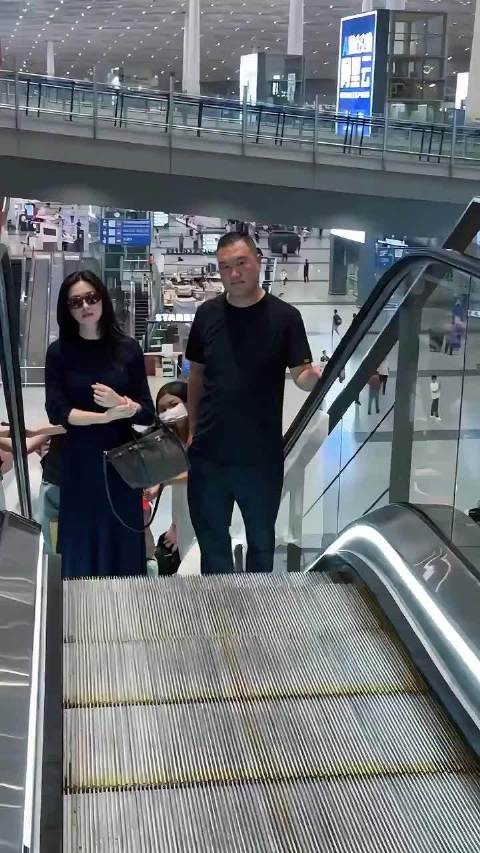 朱珠出发米兰，手拎皮衣，长卷发墨镜复古感拉满