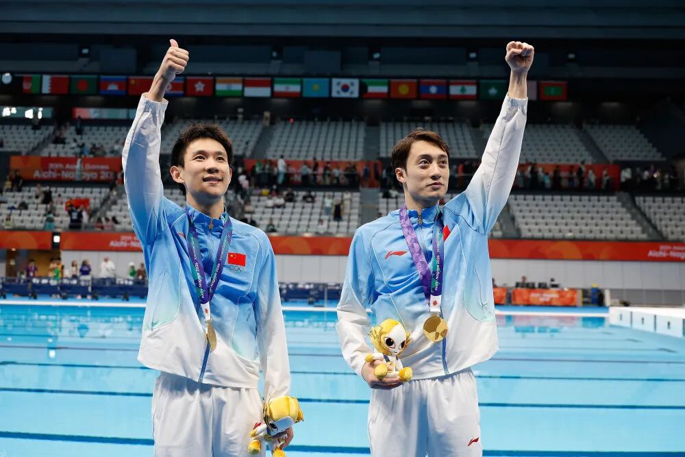 9月27日，冠军中国选手杨昊/练俊杰（右）在爱知·名古屋亚运会跳水项目男子双人10米跳台颁奖仪式后。新华社记者伍志尊摄