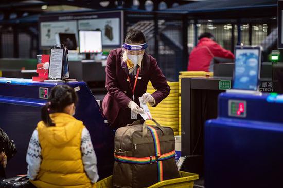 海南航空地服人员为旅客办理值机手续(摄影:蔡林昊)