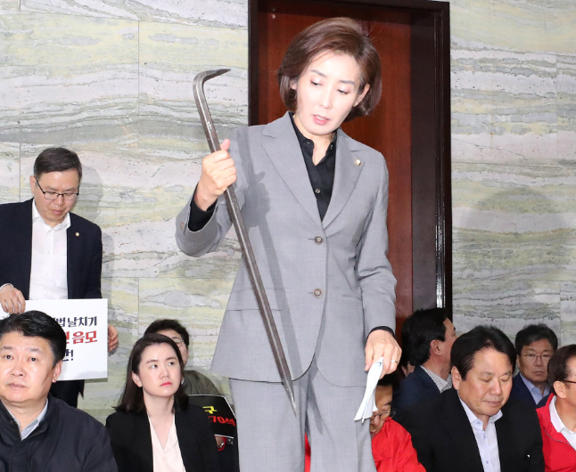 罗卿媛当众展示“缴获”的撬棍(韩国《中央日报》)