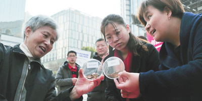 在上海南京路步行街上,一家老字号中药店工作人员向市民讲解如何鉴别真假中药材,帮助消费者提高维权能力。 人民视觉