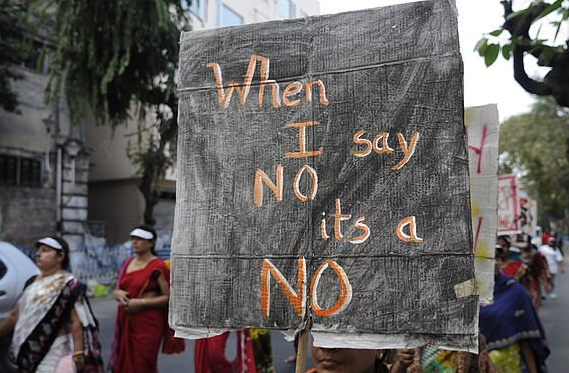 一名妇女在游行中举着牌子（图源：每日邮报）