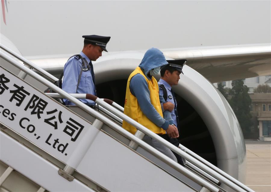 6月7日，犯罪嫌疑人被押解下飞机。新华社记者 殷刚 摄