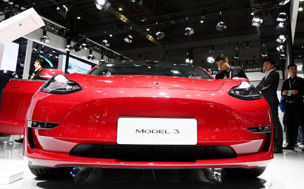 今年4月21日，参观者在上海车展特斯拉展台观看一部展出的Model 3电动车。（新华社）