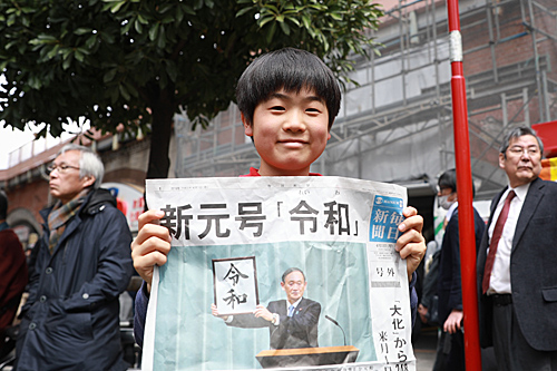 4月1日，在日本東京，一名小朋友展示當日報紙，其頭版頭條公佈日本新年號爲“令和”。（新華社）
