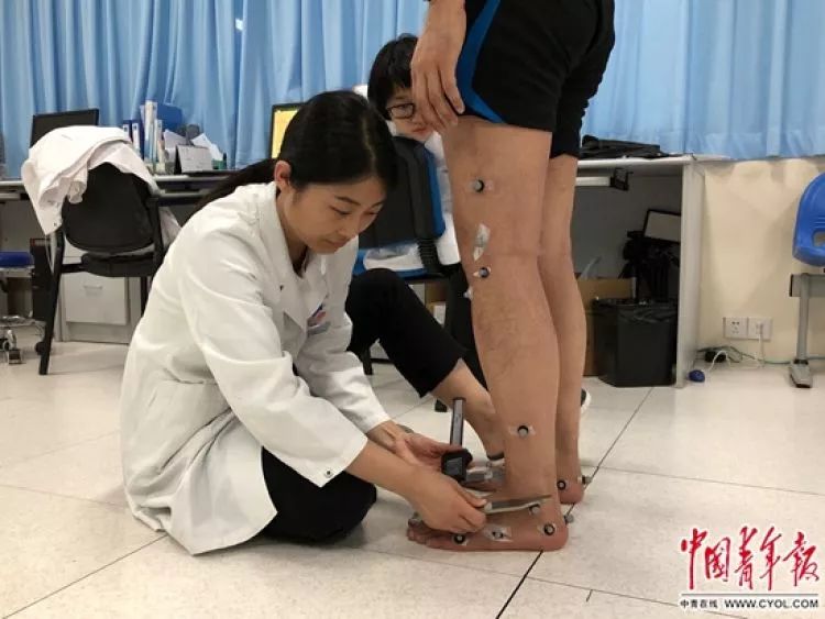 ↑医生正在给患者测量脚踝宽度,为三维步态测试提供参考数据。刘昶荣 摄