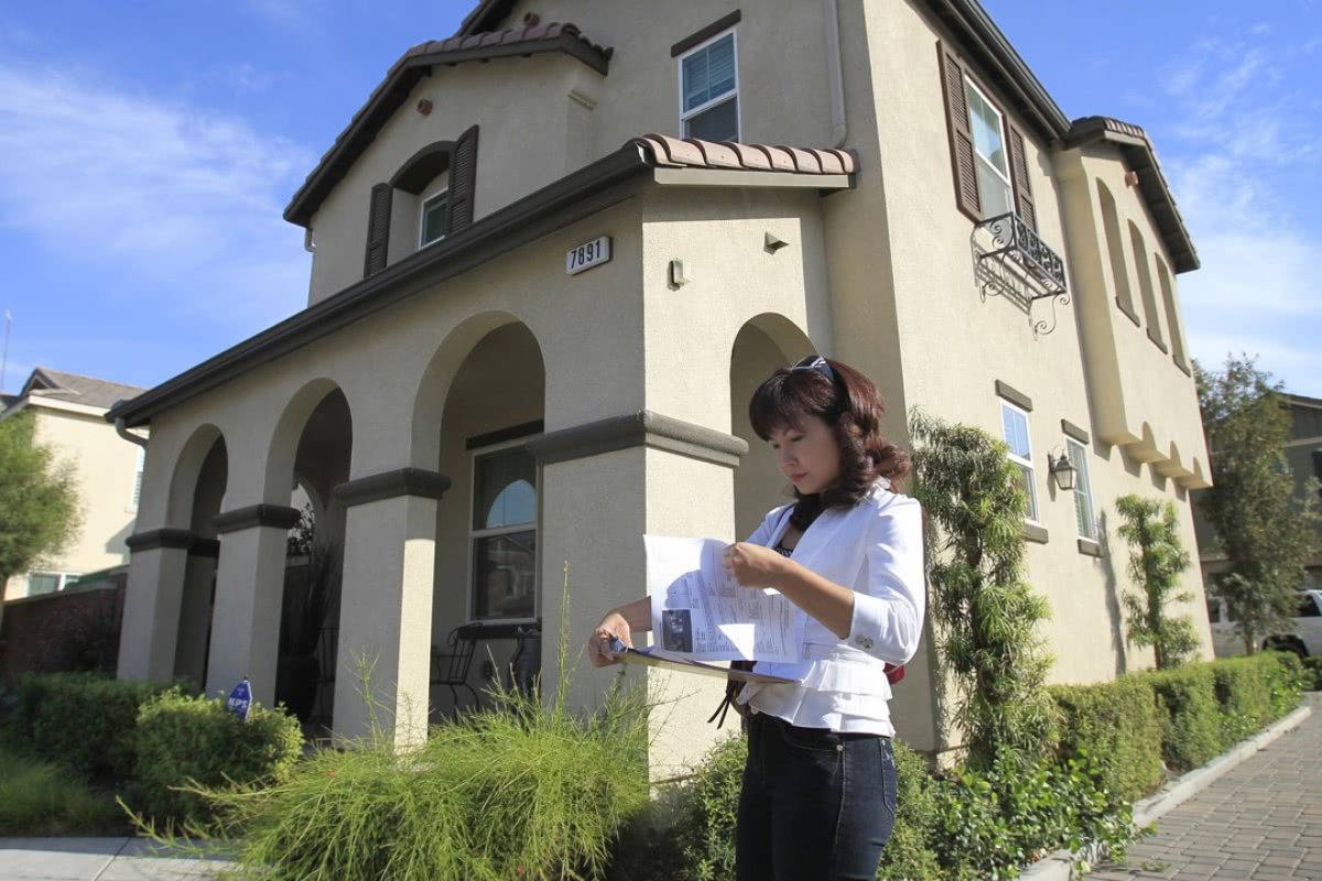 一名专注中国购房者的经纪人在南加州奇诺市的一处房产前 图自《南华早报》