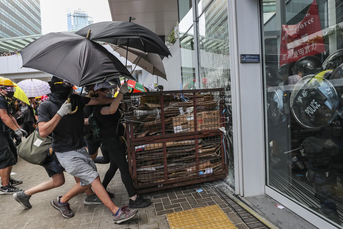 7月1日，抗议者冲击立法会大楼的窗户 港媒图