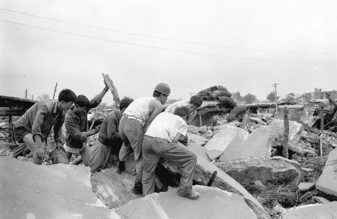 这是1976年7月28日大地震发生后，人们在清理废墟。新华社记者 官天一 摄