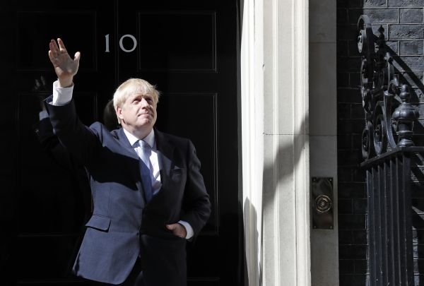 资料图片：7月24日，英国新就任首相鲍里斯·约翰逊在唐宁街10号首相府门口挥手致意。（新华社/美联）