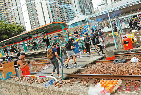 图为香港暴徒将杂物扔在铁轨上阻碍交通（来源：文汇报）
