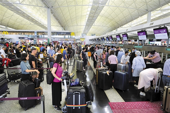 8月14日,旅客在香港国际机场排队办理值机手续 新华社发