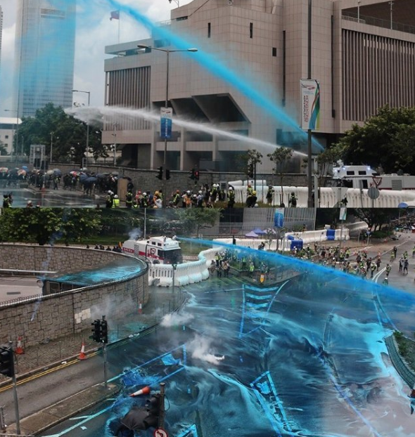 　图为香港警方水炮车向非法示威者发射蓝色水柱（来源：港媒）