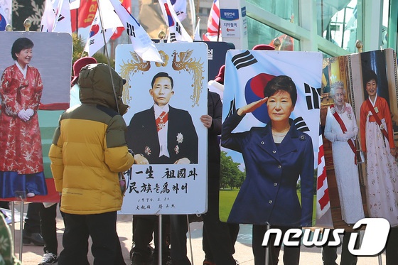 韩国上万民众示威 举朴槿惠父女照片星条旗铺一