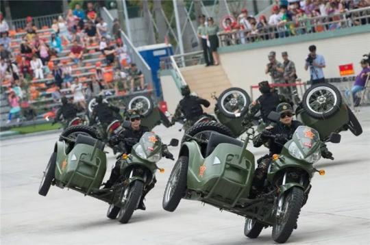 驻澳门部队骑摩托女兵秀特技 翻斗一侧轮胎离地