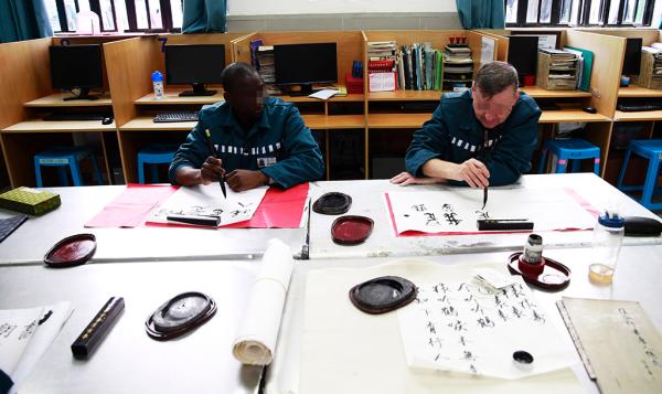 两名外籍服刑人员在练习中国书法。澎湃新闻记者 赵昀 图