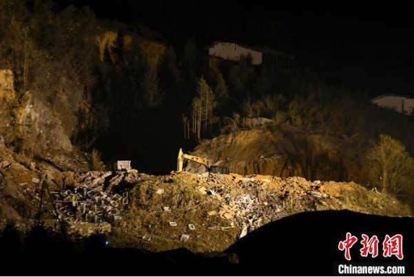  ▲挖掘机和工作人员在清理现场/杨华峰 摄