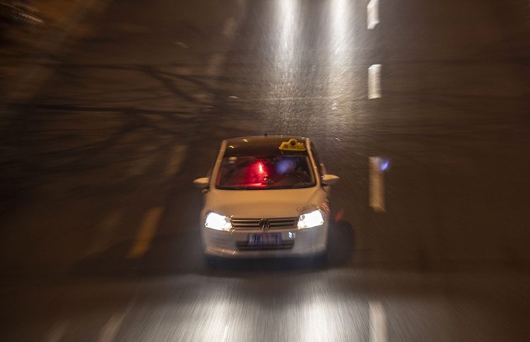 12月24日，三里屯，一辆车内悬挂彩灯、车顶放有出租车顶灯的车辆驶过。